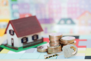 Key, coins and model of a house